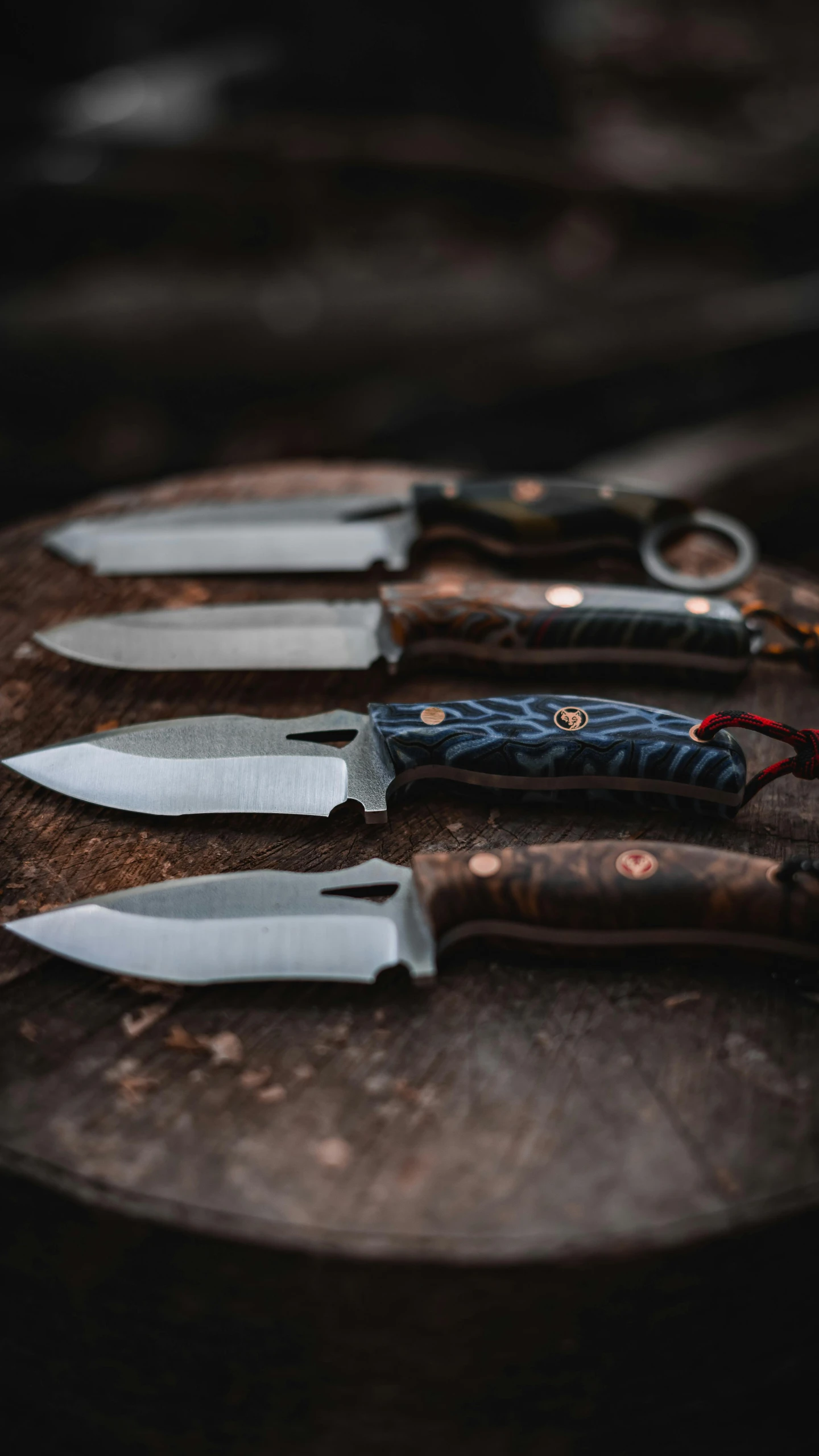 five knives on an old wood surface