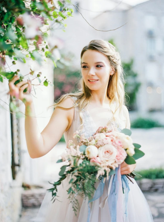 a woman holding flowers and posing for a pograph