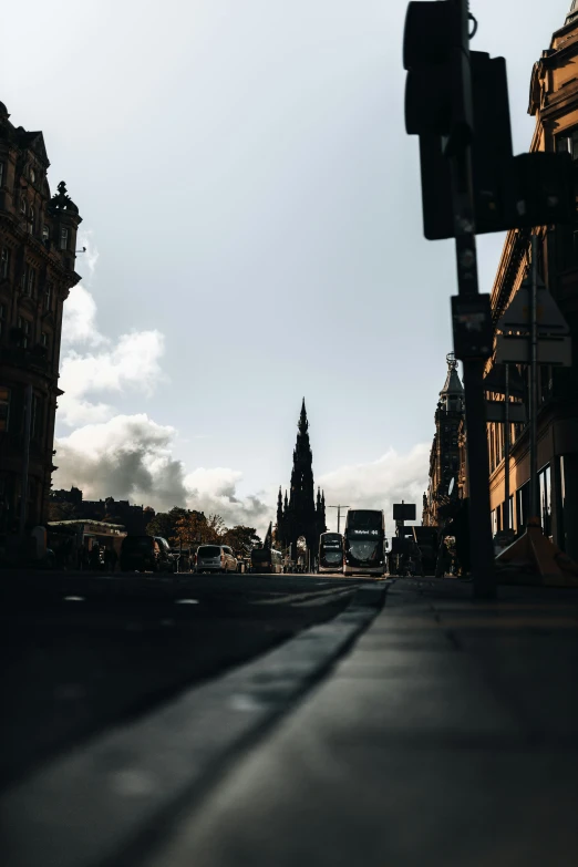 sun shining on buildings and a street with two traffic lights