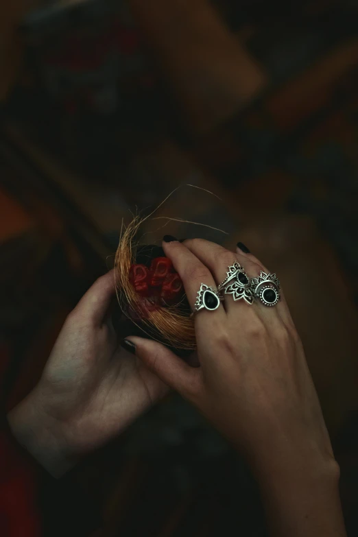 a woman's hand holding onto a wooden bowl with three rings
