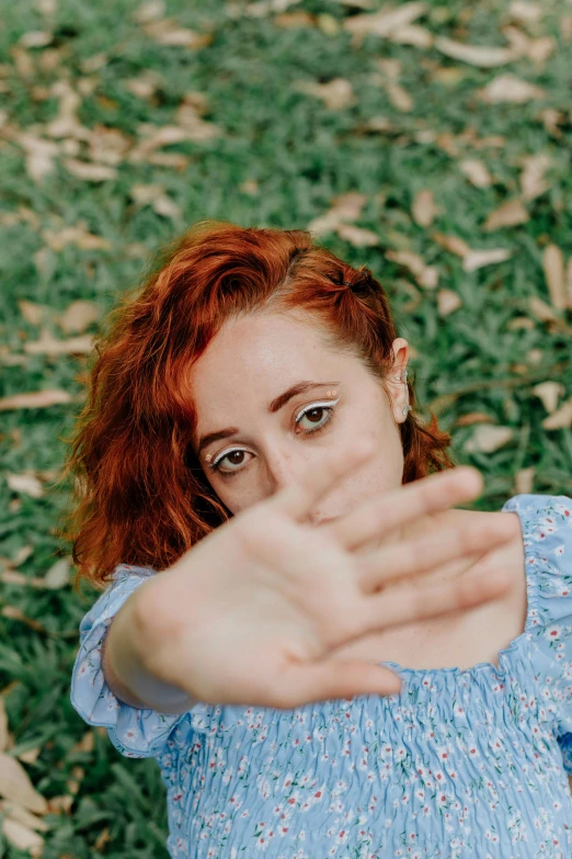 young red haired woman with eye contact on green grass