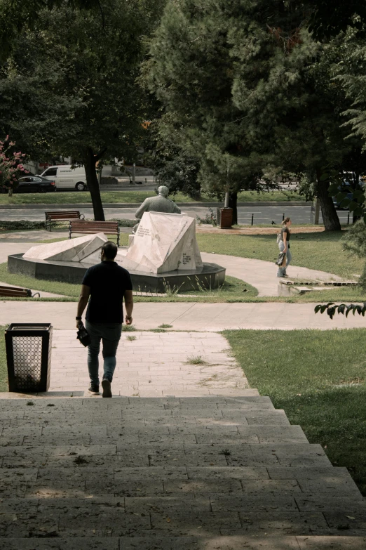 the person walks up the steps toward the statue