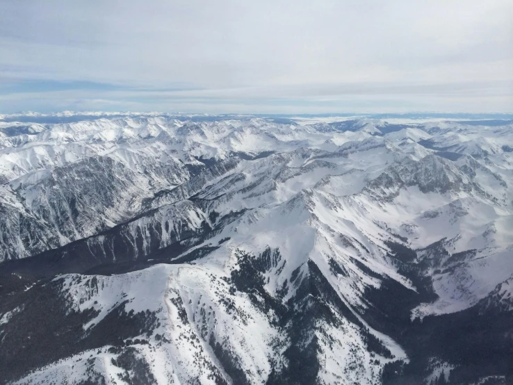 aerial pograph of snow covered mountains in the wilderness