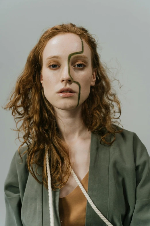 a woman with long curly hair and a green sweater