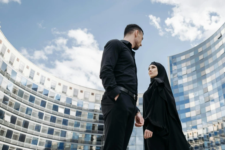 a man and woman in muslim attire staring at each other