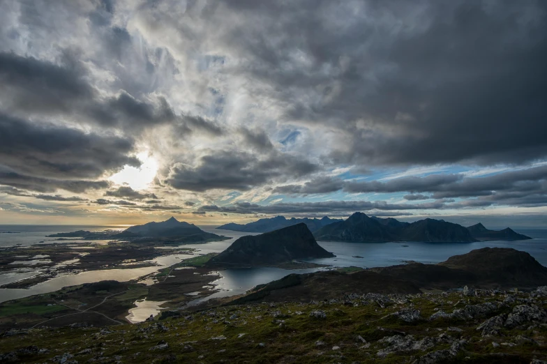 the clouds gather above the mountains and ocean