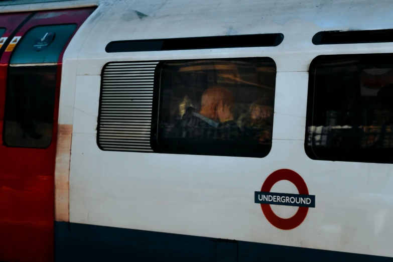 two people are seen in the windows of a subway train