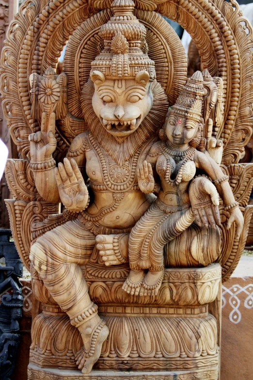 carved wooden sculpture of lord and goddess in center of courtyard