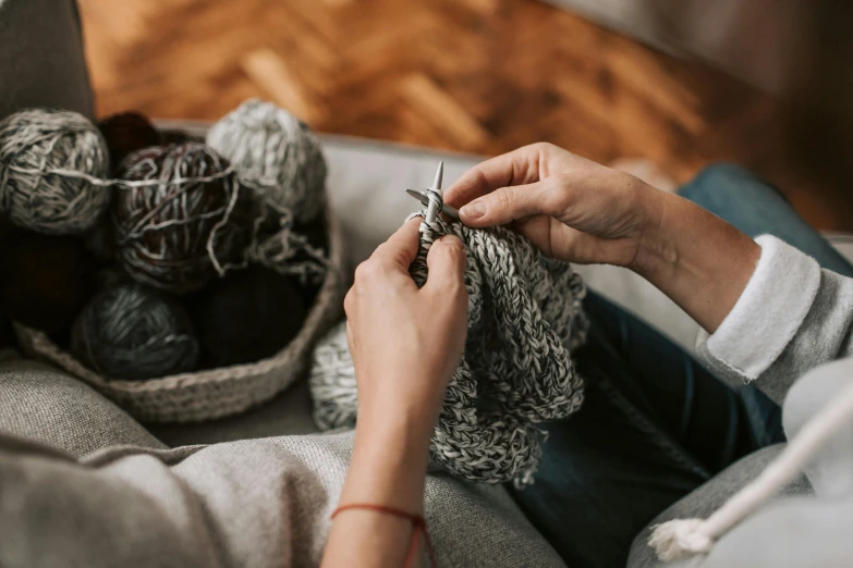 the woman is knitting her hands with her fingers