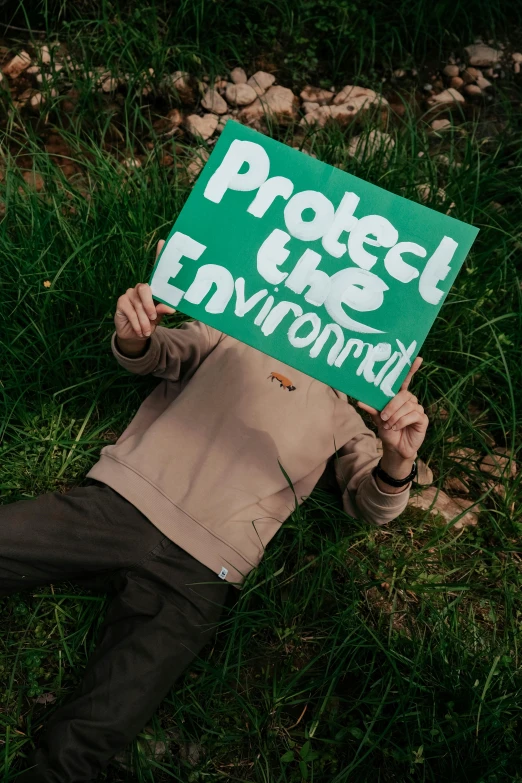 the man is holding up a green sign