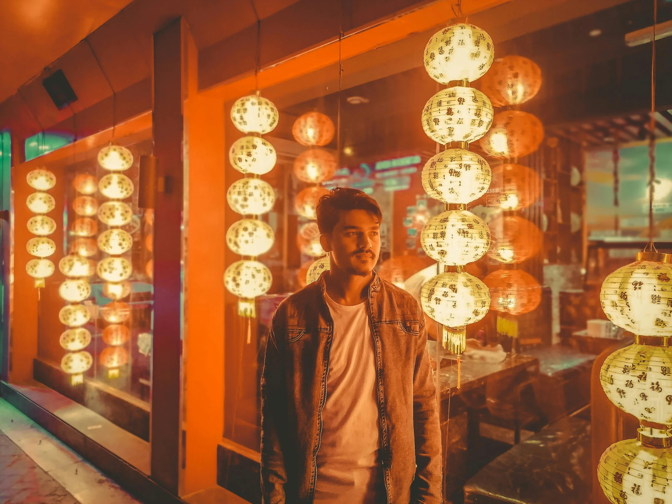 a man standing in front of a display case with asian lanterns in the background