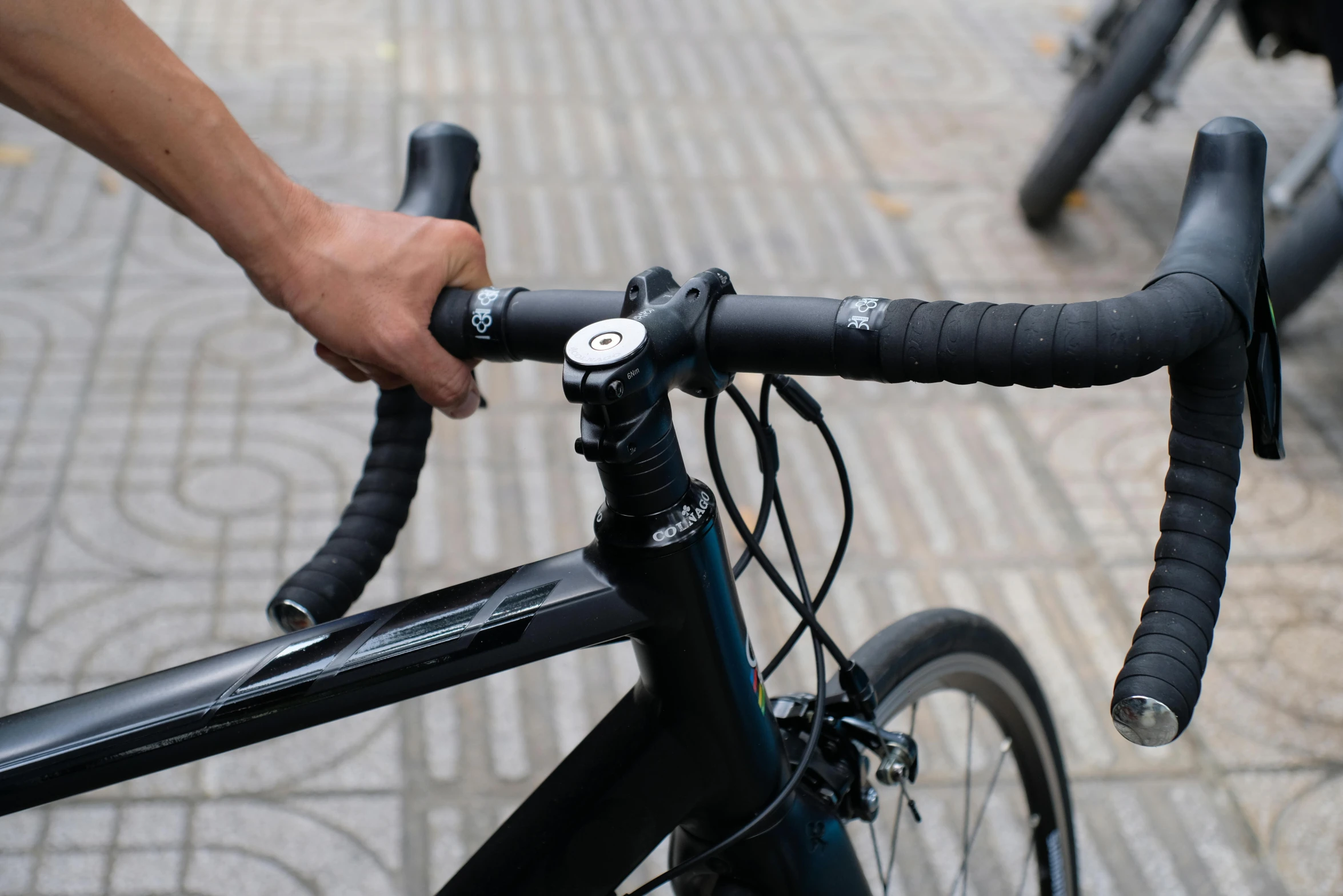 there are many hands holding the handlebars on the bicycle