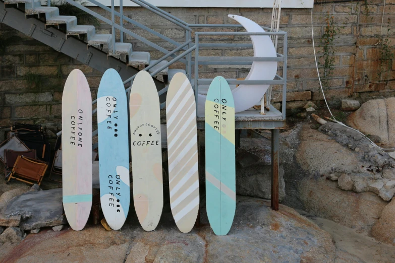 four surfboards on top of each other and a metal railing