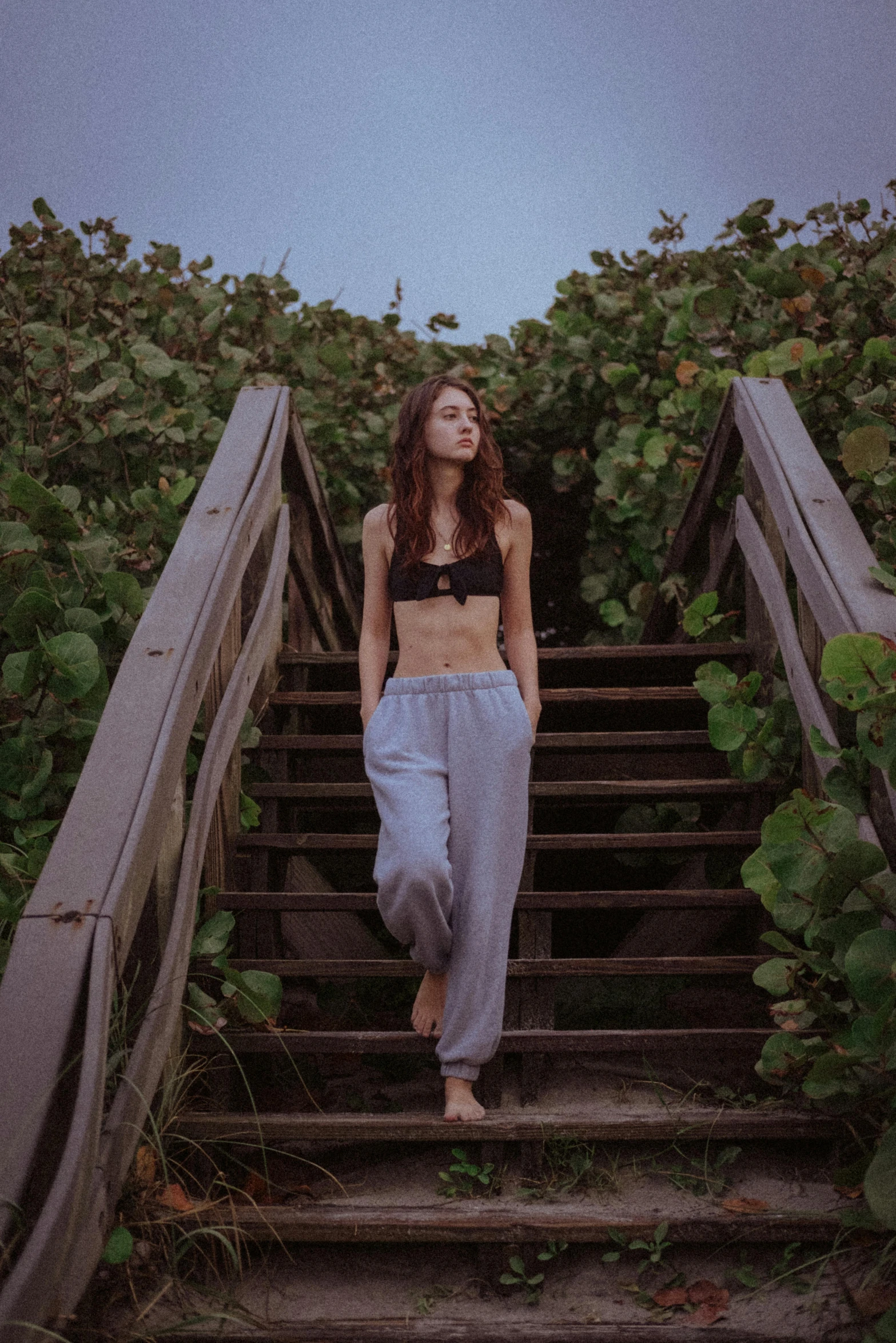 a woman in cropped top walking down a set of stairs