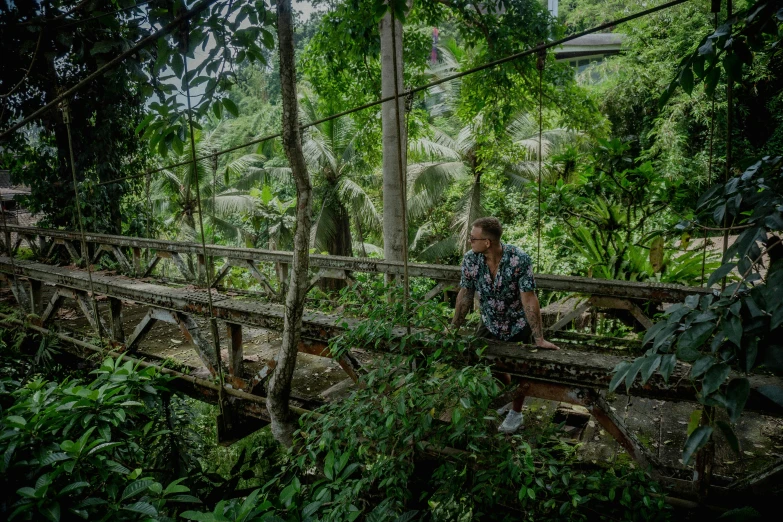 a woman is sitting on an old fashioned wooden bridge