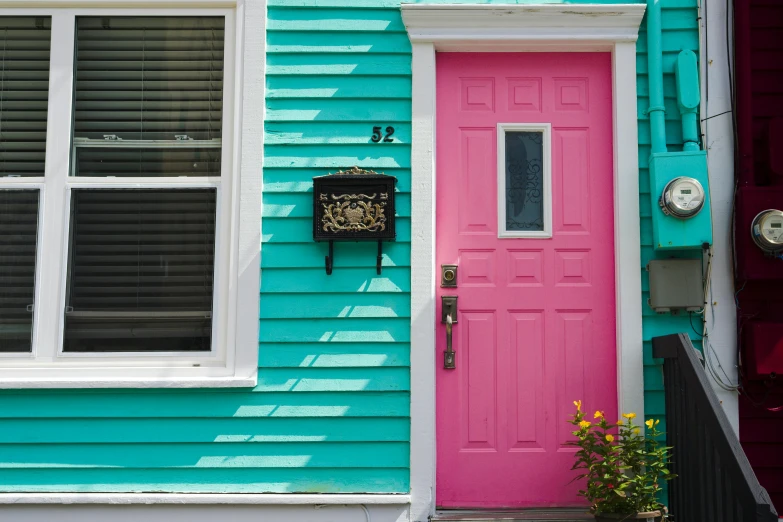 a pink and blue door next to a red door