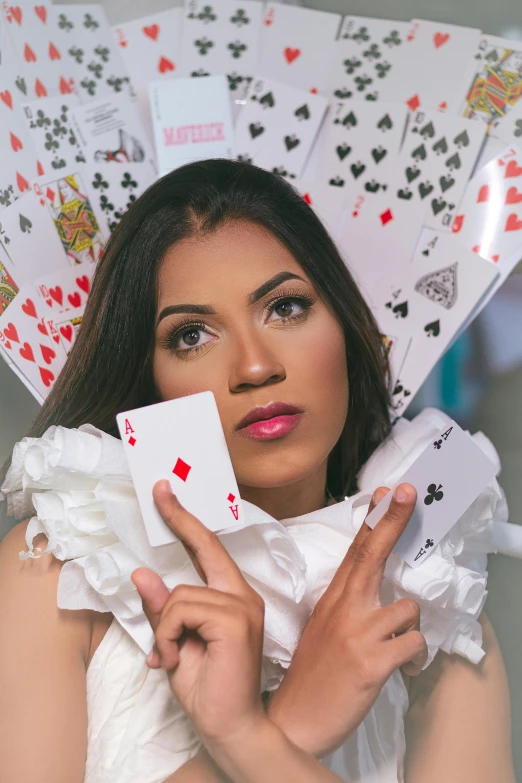a woman is holding playing cards in both hands