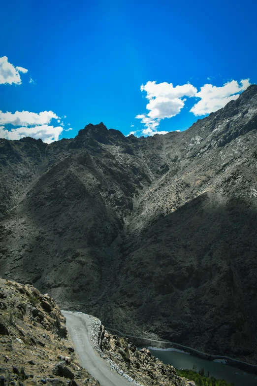 a mountain and road side by side with water on it