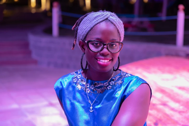 a woman in blue shirt and glasses smiling