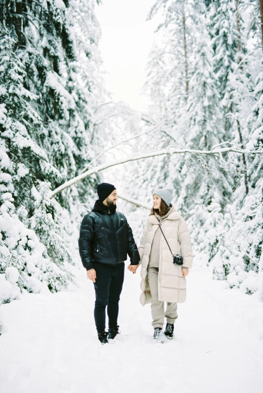 a man and woman holding onto some wires in the snow