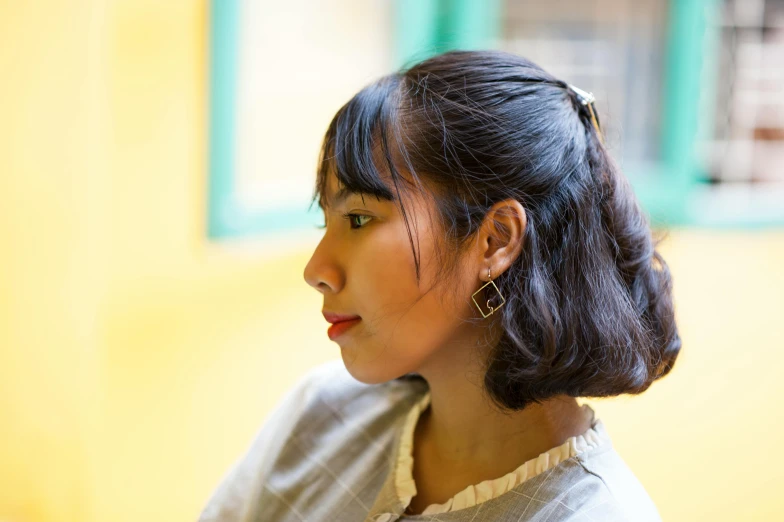 a woman wearing ear rings and looking away