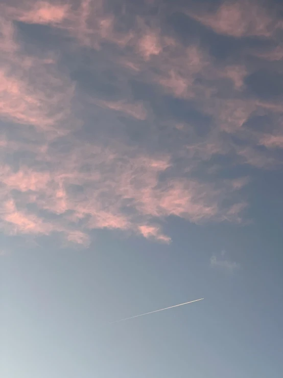 a white airplane flying through a cloudy blue sky