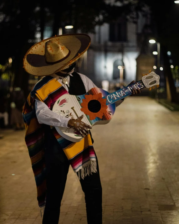 a person in a mexican suit is holding a skateboard