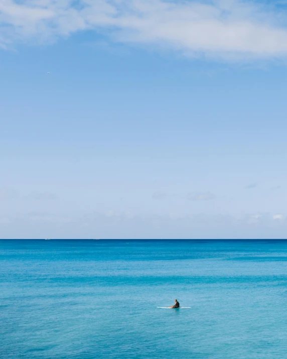 people are floating in the open water with surfboards