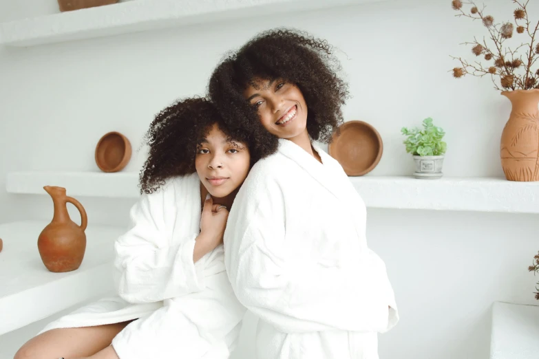 two women in robes are emcing each other