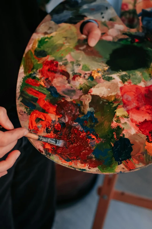 an artist's hands holding up a palette
