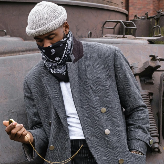 a man wearing a coat and scarf using his cell phone