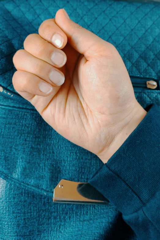 a person holds up a knife blade to their hand