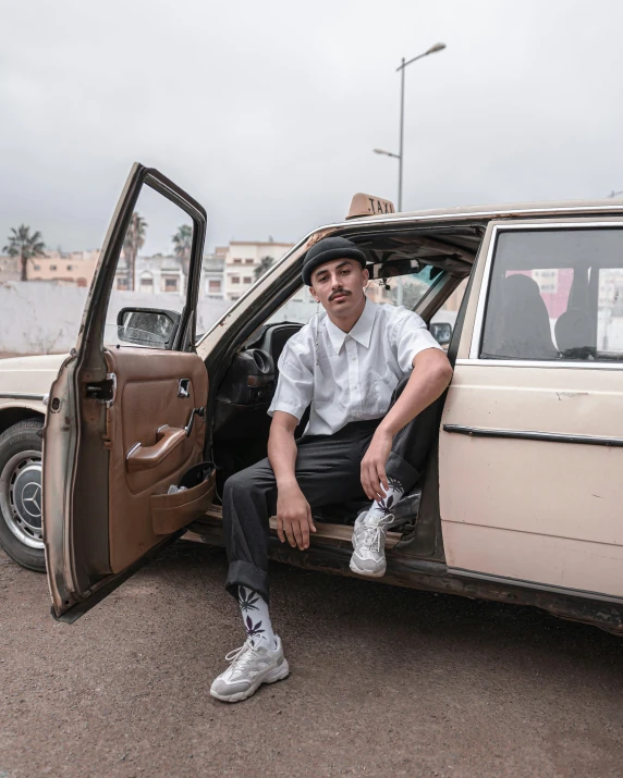 the young man is sitting in his car