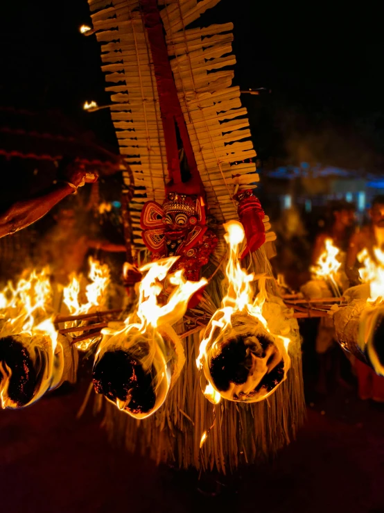 fire dancing at a festival with large yellow torches