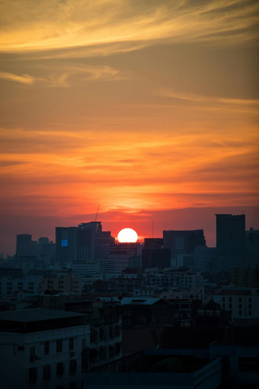 the setting sun is above the city skyline