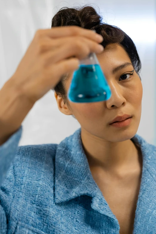 the woman holds a blue object to her head