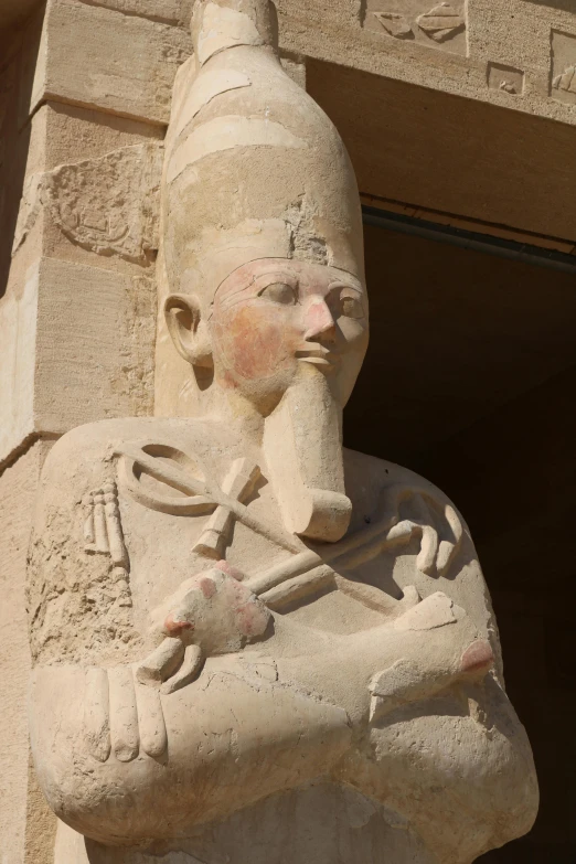 a large statue of a pharaoh on display in front of a building