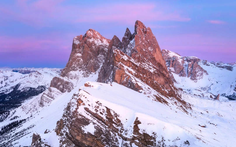 a mountain landscape with several large rocks in the snow