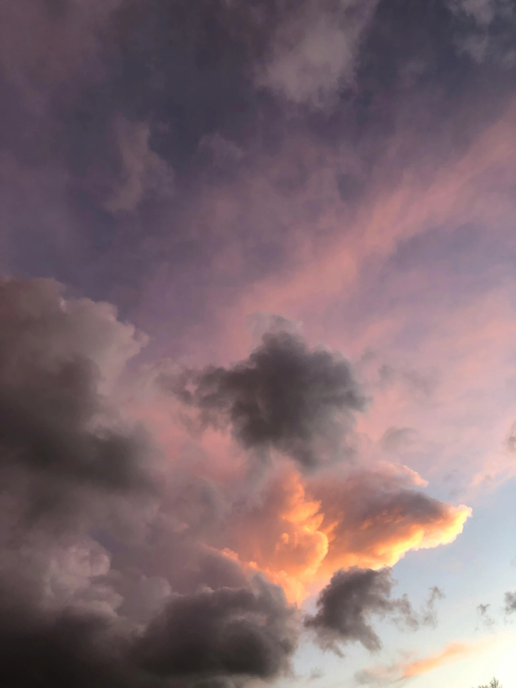 some clouds are in the sky at sunset