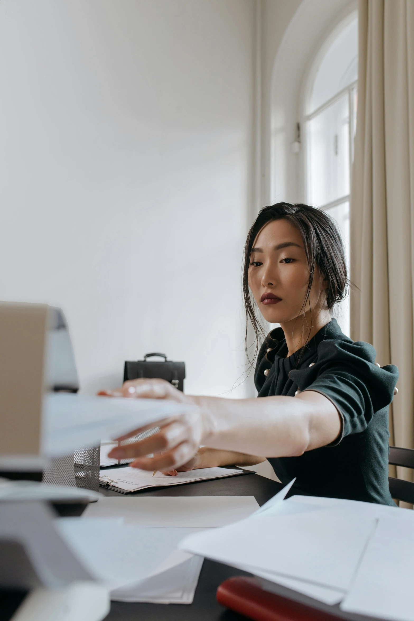 a woman working at a desk with a laptop