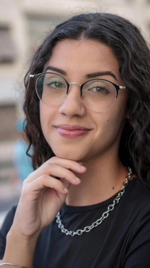 a woman with glasses and a long necklace