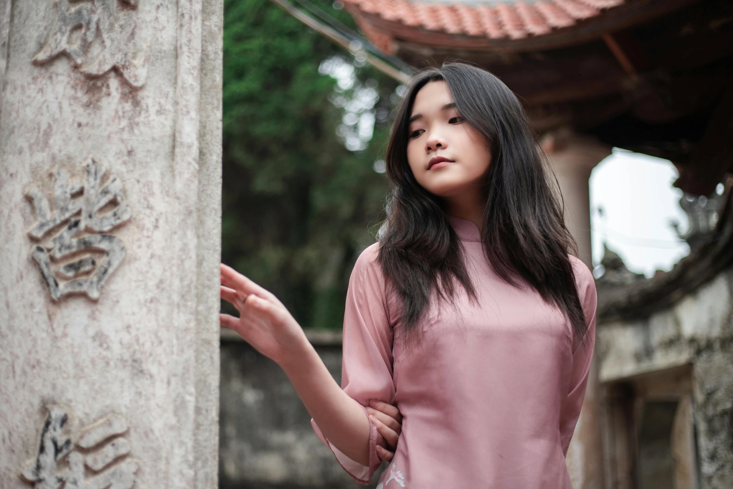 woman standing near column in asian walled area