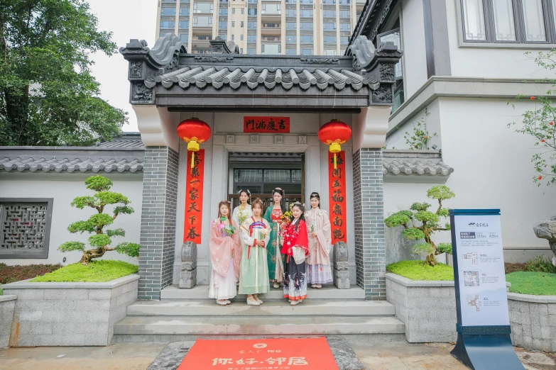 asian ladies are gathered at the entrance to an ancient temple