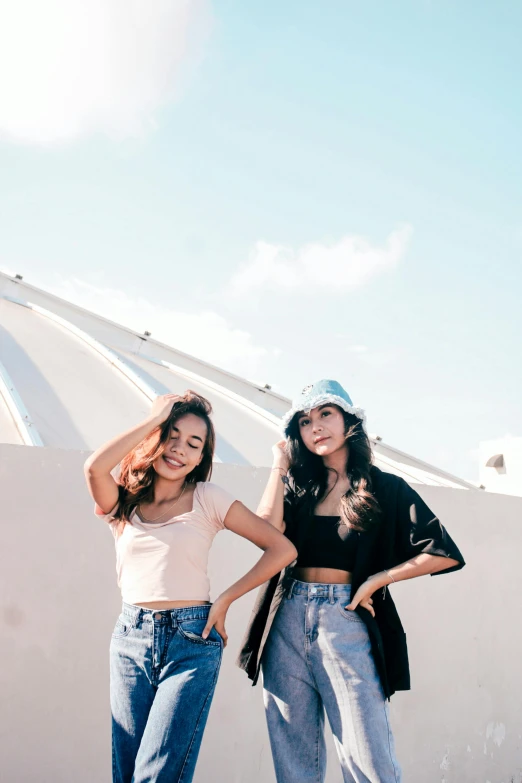 two women standing together in denim clothing