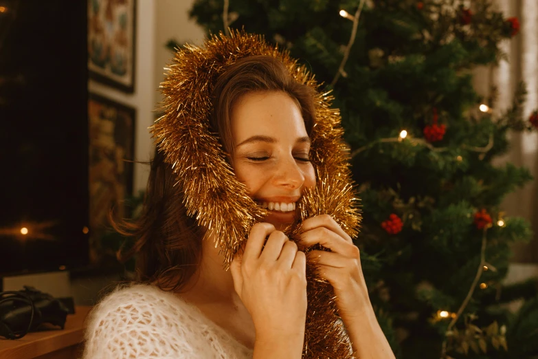 the woman smiles while putting on tinsel