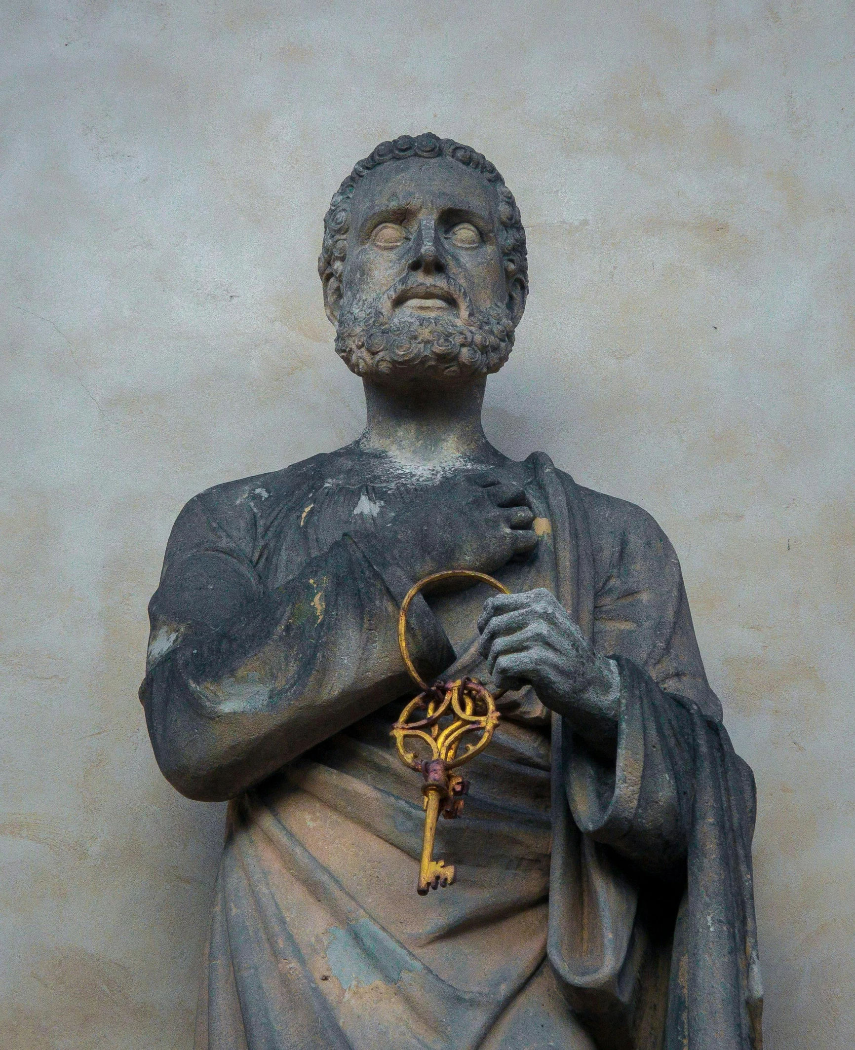 a statue holding a key in his hand with his left hand