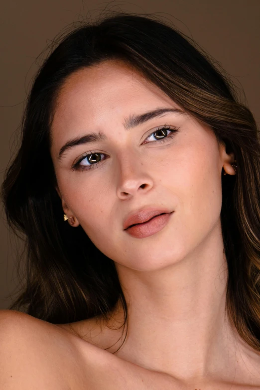 a woman in a strapless top with two pairs of earrings on her neck