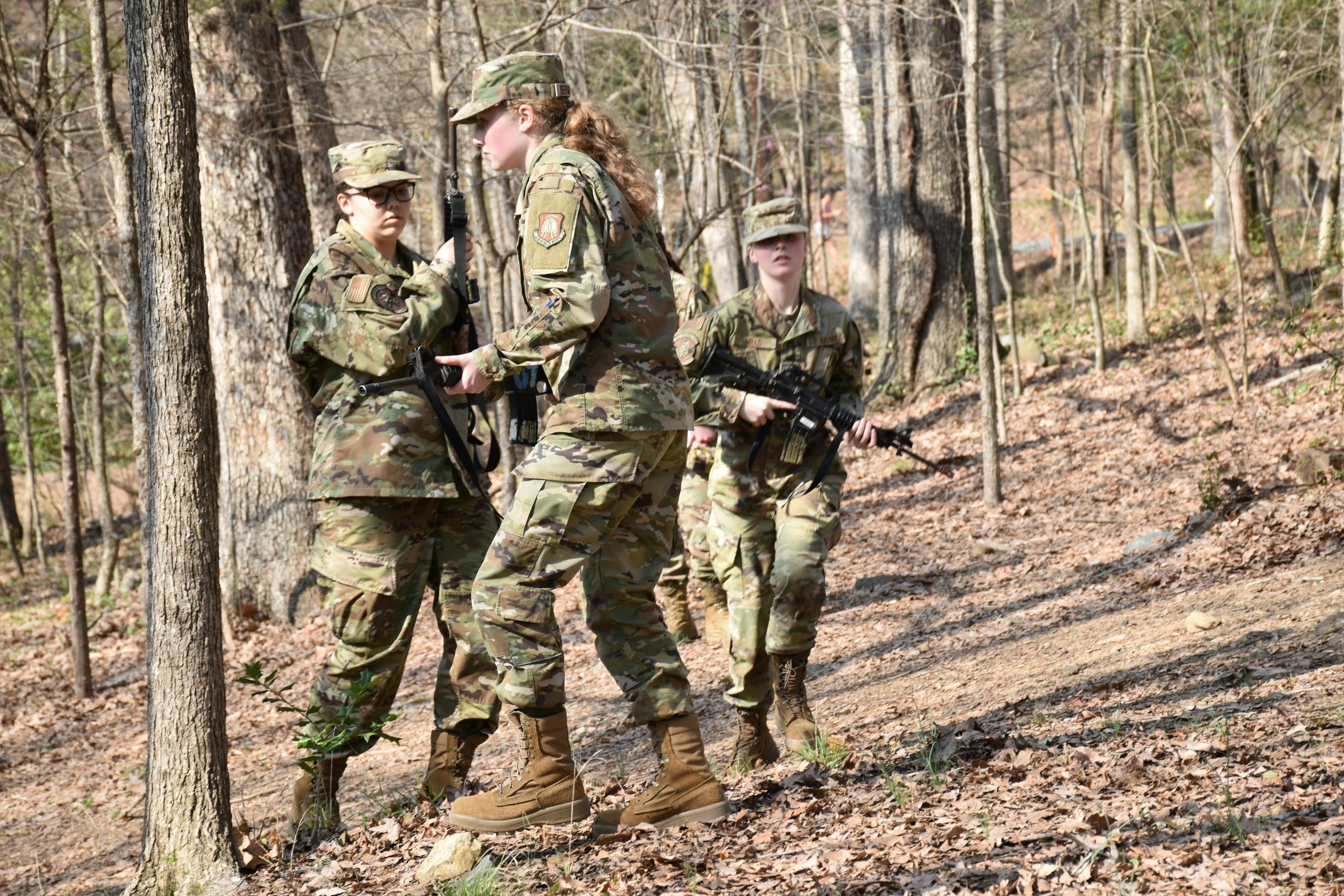 three soldiers in the woods with guns