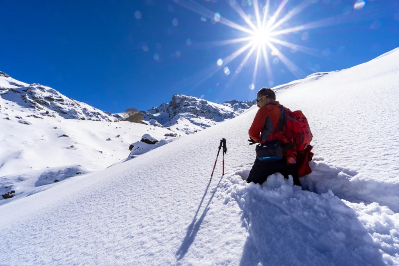 a person kneeling down in the snow with ski poles