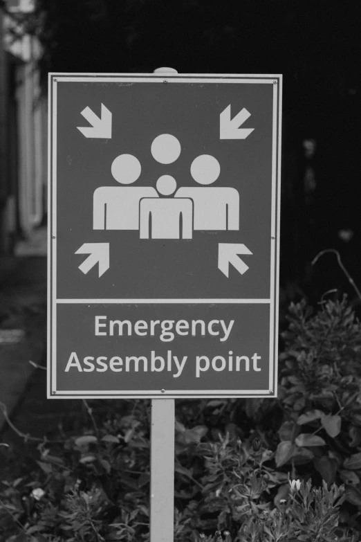 the sign is pointing to emergency assembly point